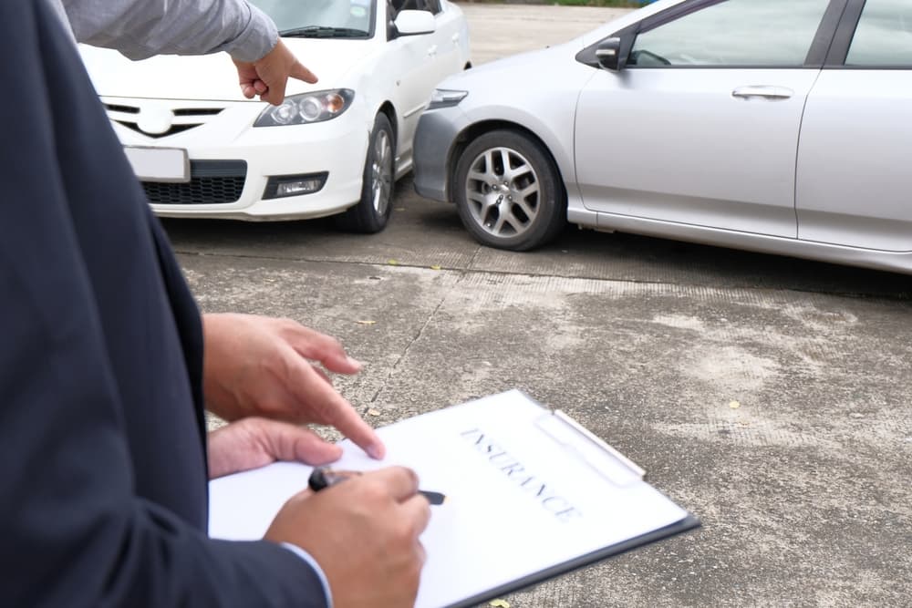 An insurance adjuster inspecting a damaged car.