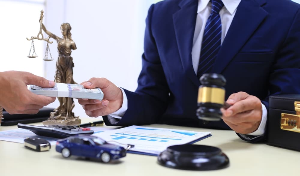 Judge's gavel with a businessman or lawyer in a suit working on legal documents, symbolizing law, legal advice, fees and justice.






