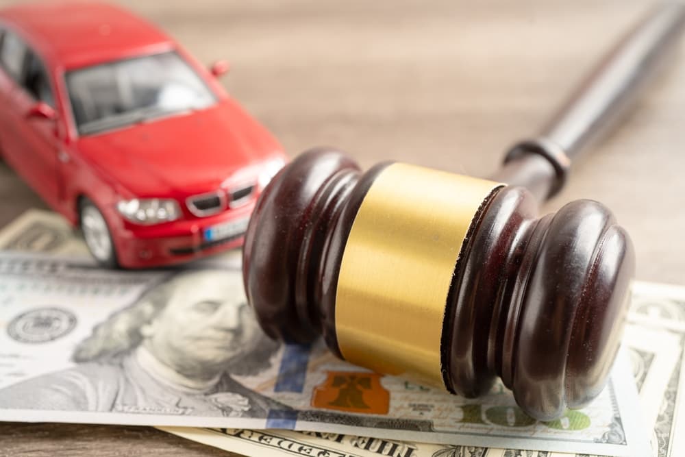 Hammer gavel judge and US dollar banknote money with car vehicle accident,