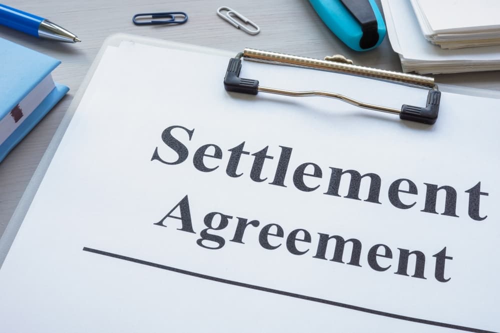Close up of clipboard with settlement agreement.