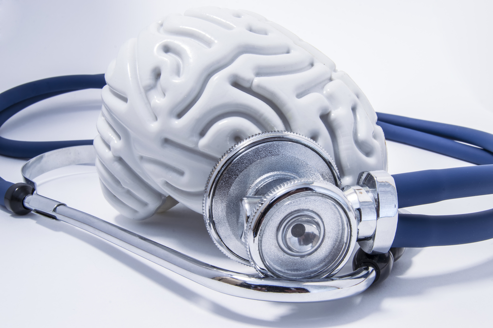 Medical stethoscope placed on brain model representing traumatic brain injury evaluation